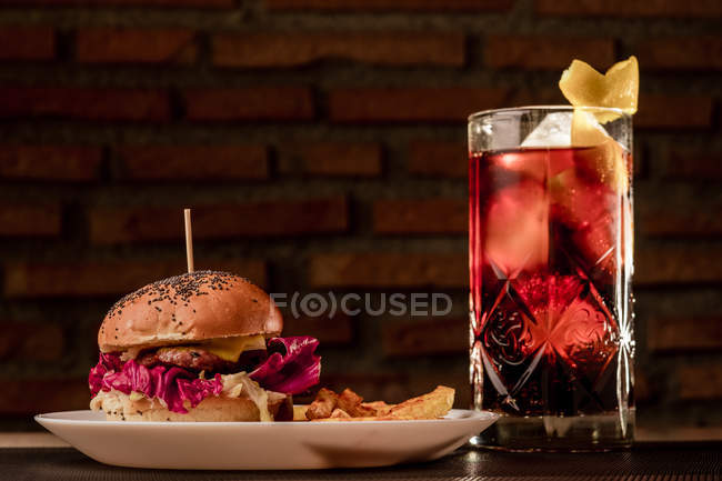 Tasty burger with french fries on plate and glass of coke — Stock Photo