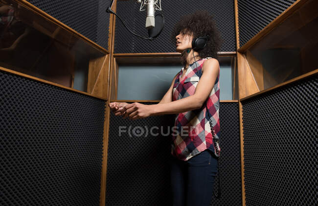 Молода жінка співає в студії — стокове фото