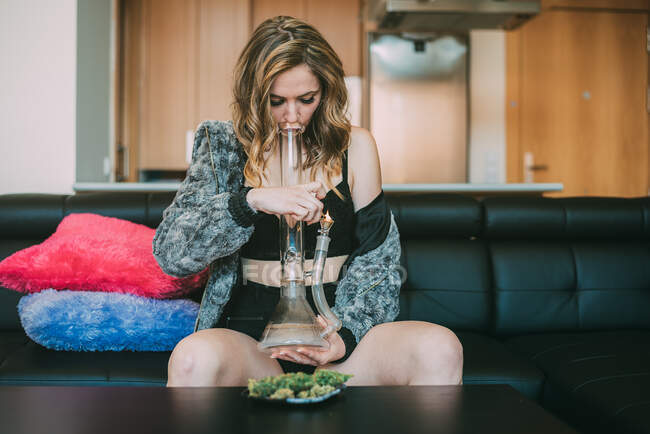 Femme fumant de la marijuana dans un bong — Photo de stock