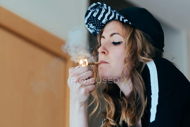 Junge Frau zündet sich Cannabis-Joint an — Stockfoto