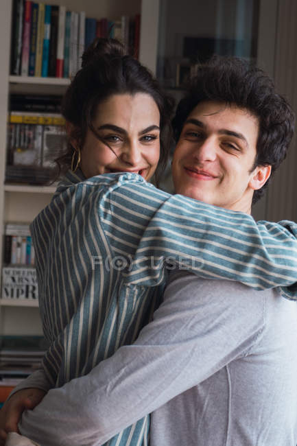 Retrato de abraçar jovem casal em pijama em casa — Fotografia de Stock