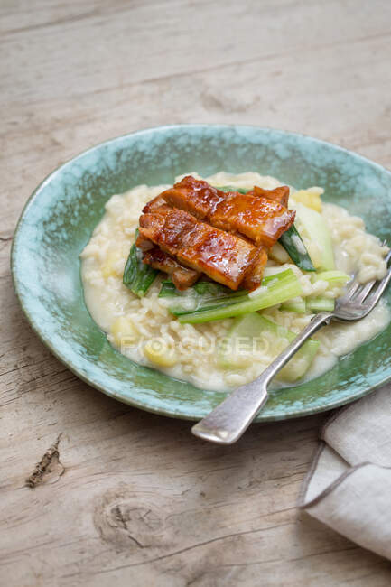 Close-up appetizing tasty risotto with bok choy on wooden table. — Stock Photo