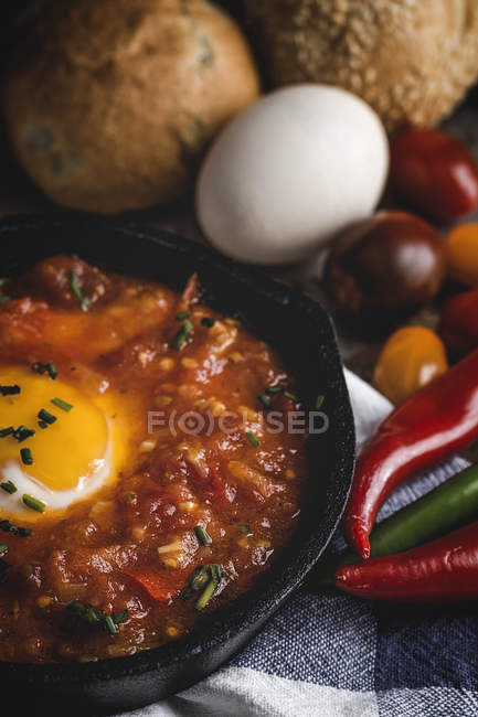 Fried egg with tomato and red and green peppers in frying pan — Stock Photo