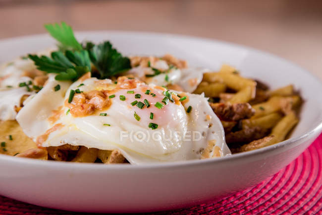 Appetitliche Portion pochierter Eier, serviert im Teller mit Pommes frites — Stockfoto