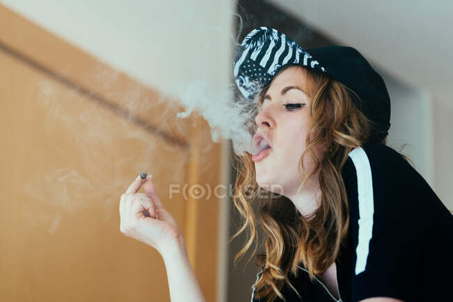Jeune femme fumant un joint de cannabis — Photo de stock