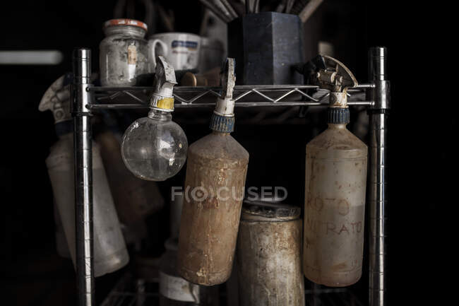Vue de la récolte du stand avec pulvérisateur pulvérise des bocaux en verre dans la fonderie sur fond noir — Photo de stock
