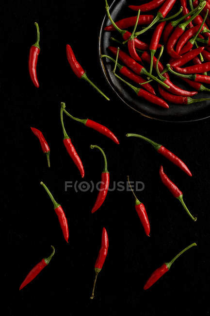 Pfanne mit roten Paprika auf schwarzem Hintergrund — Stockfoto