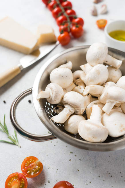 White mushrooms and ingredients for cooking on table — Stock Photo