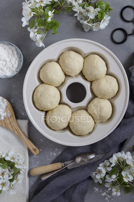 From above uncooked buns prepared for baking placed on a plate. — Stock Photo