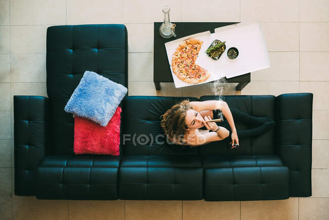 Жінка лежала на дивані з марихуаною. — стокове фото