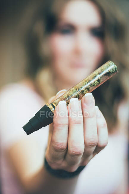 Женщина готовит марихуану в стеклянном тупом виде — стоковое фото
