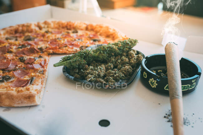 Марихуана или растение конопли и пицца — стоковое фото
