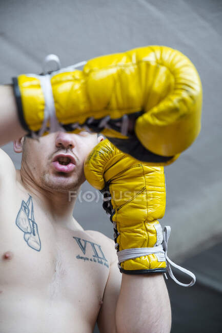 Fiducioso combattente sportivo senza maglietta in piedi con i pugni alzati e guardando la fotocamera. — Foto stock