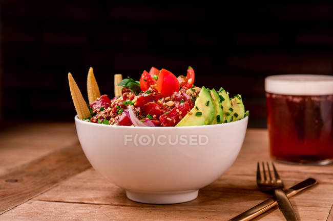 Bowl of tasty vegetable salad with avocado on wooden table — Stock Photo