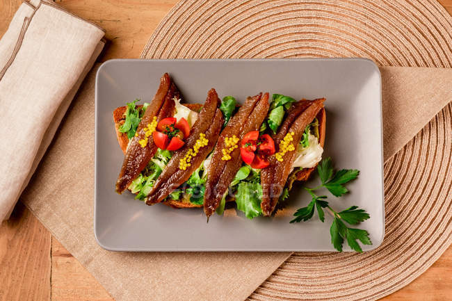 Sanduíche com legumes e peixe em prato cinzento — Fotografia de Stock