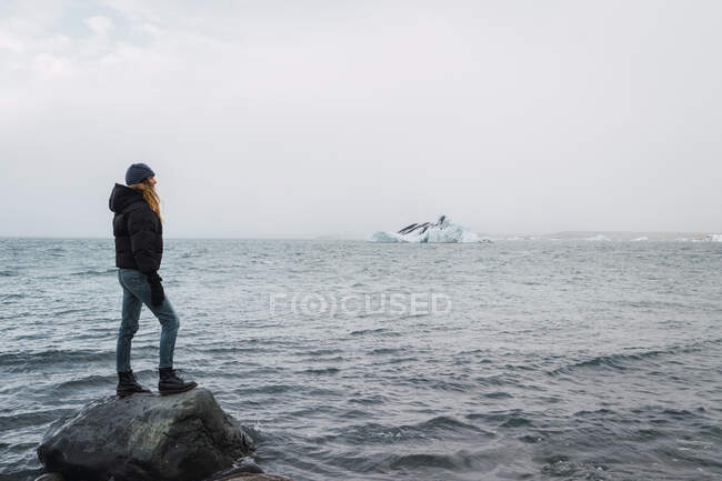 Mädchen steht auf Felsen im Meer — Stockfoto