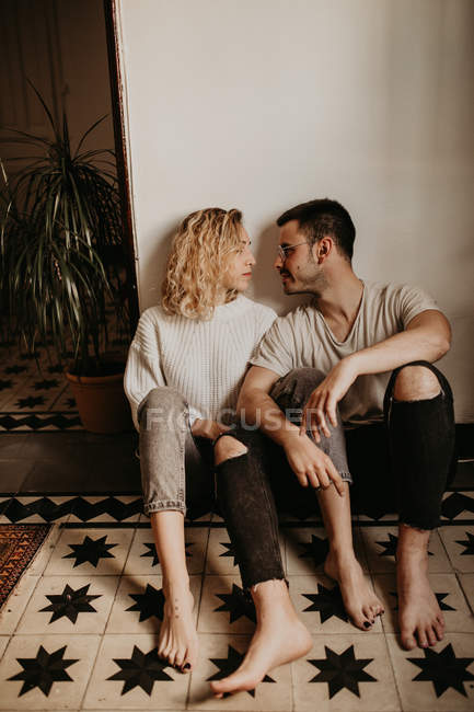 Romantique homme et femme assis sur le sol à la maison ensemble — Photo de stock