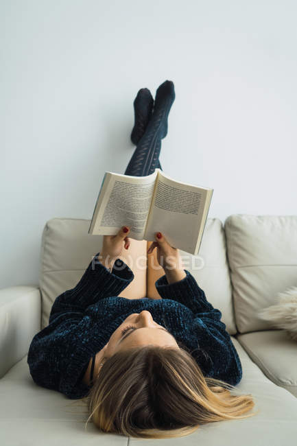 Ragazza bionda assorbita con la lettura in pullman a casa — Foto stock