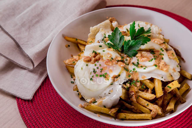 Appetitliche Portion pochierter Eier, serviert im Teller mit Pommes frites — Stockfoto