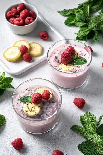 Сладкий смузи с ягодами в стаканах на белой поверхности — стоковое фото
