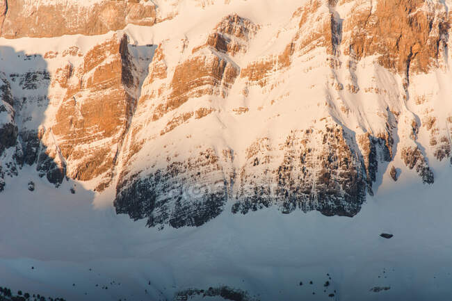 Vista para a colina branca coberta de neve em luz solar laranja na natureza. — Fotografia de Stock