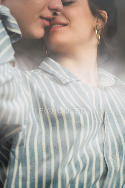 Close-up of sensual couple kissing behind window — Stock Photo