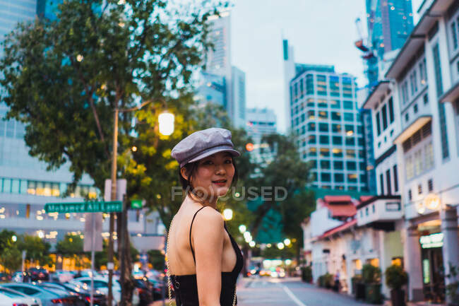 Mujer asiática en ropa elegante caminando por la calle - foto de stock