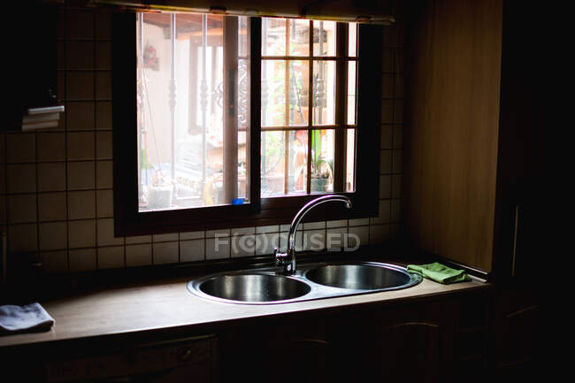 Внутрішній знімок кухонної лічильника з раковиною біля маленького вікна в денне світло — стокове фото