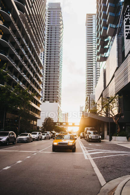 Yellow taxicab riding on road among skyscrapers in city of Miami — Stock Photo