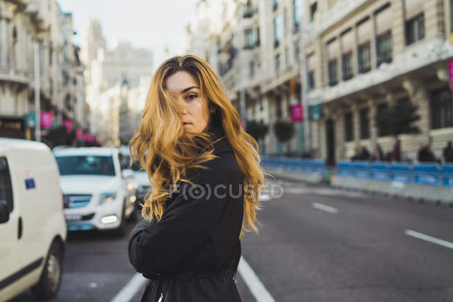 Молода жінка позує по дорозі в місто — стокове фото