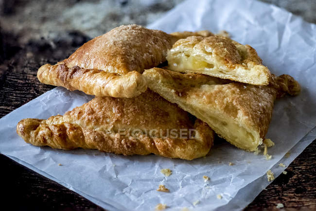 Crunchy flaky pastry on paper napkin on wooden table — Stock Photo