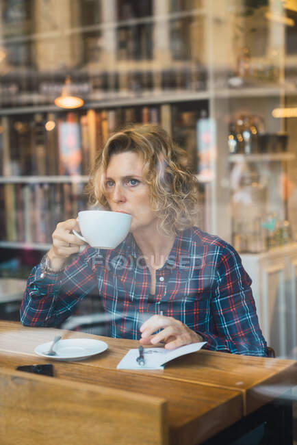 Woman sitting in cafe and writing in notebook — Stock Photo