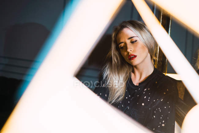 Молода блондинка приваблива жінка відображає в дзеркалі вдома — стокове фото