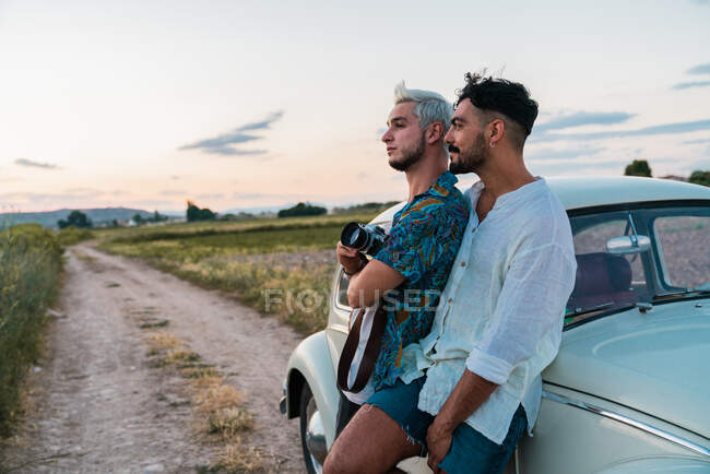 Мужчины общаются с ретро камерой и винтажным автомобилем — стоковое фото