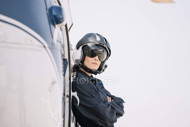 Pilote fille pose avec son hélicoptère et casque — Photo de stock