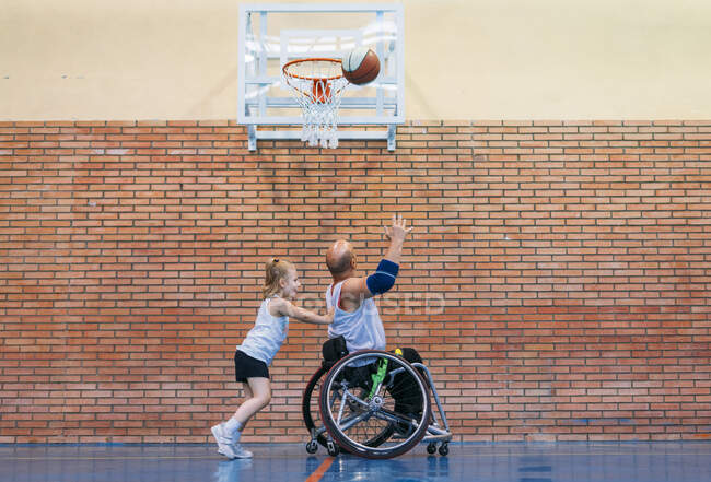 Deficientes homens do esporte e menina em ação enquanto joga basquete indoor — Fotografia de Stock