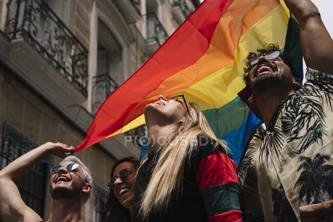 Grupo de amigos com uma bandeira de orgulho gay na cidade de Madrid — Fotografia de Stock