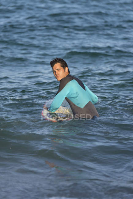 Male surfer surfing with surfboard in the sea on a sunny day — Stock Photo
