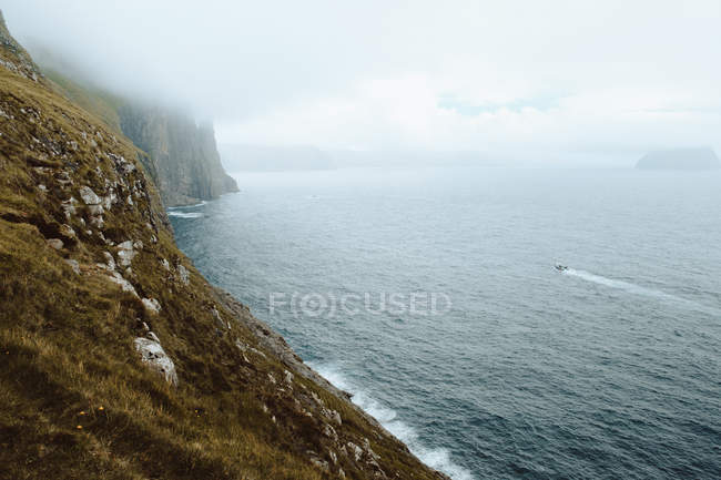 Oceano e penhasco rochoso nas nuvens na Ilha Feroé — Fotografia de Stock