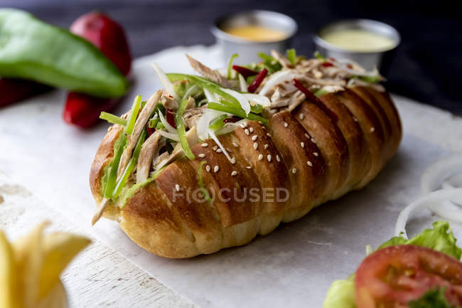 Большой сэндвич с овощами и жареной картошкой на салфетке — стоковое фото