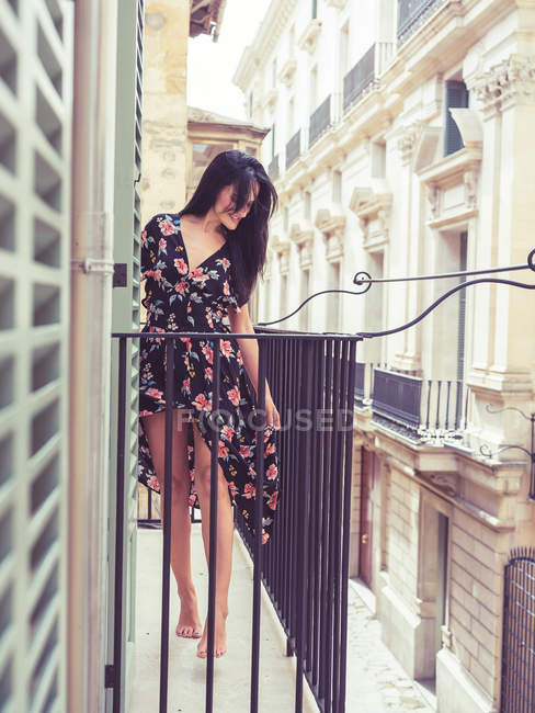 Красива молода жінка стоїть на балконі в місті — стокове фото