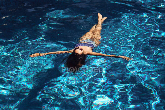 Frau liegt auf blauem, transparentem Wasser — Stockfoto
