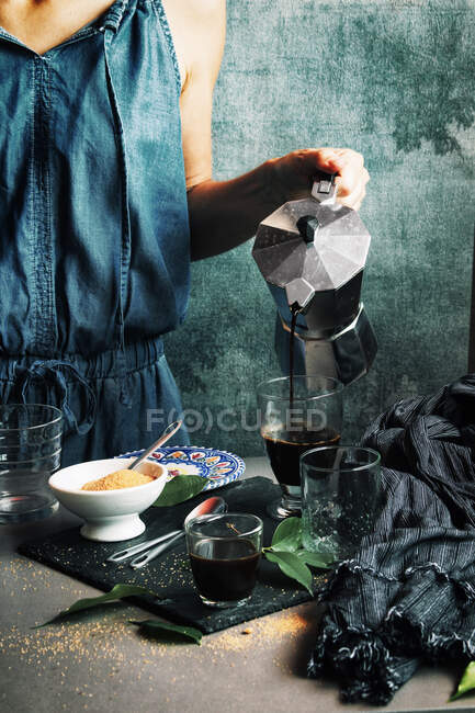 Woman serving coffee in crystal glass — Stock Photo