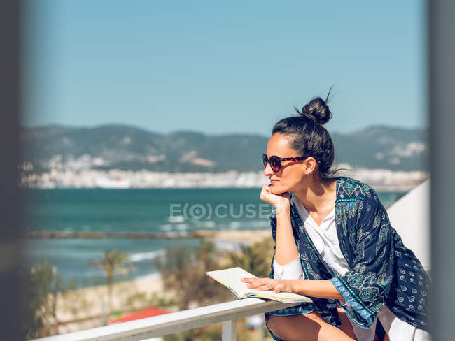 Mulher com livro na varanda — Fotografia de Stock