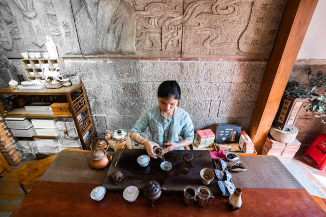 Jeune femme asiatique faire des préparations et brassage de thé oriental — Photo de stock