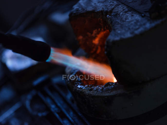 Primer plano de la calefacción de metal en la fábrica de joyas - foto de stock