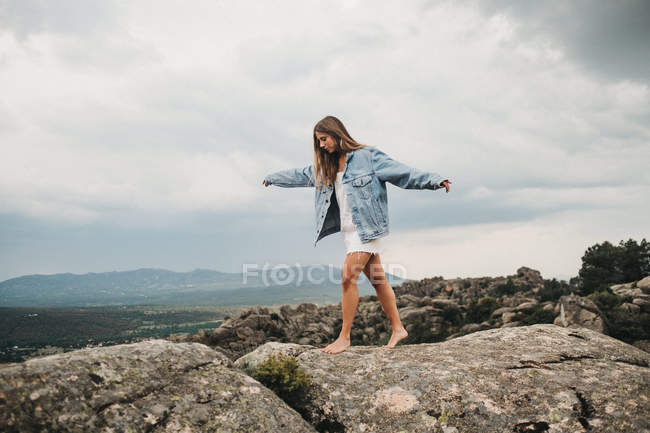 Femme sautant par-dessus fissure sur les pierres — Photo de stock