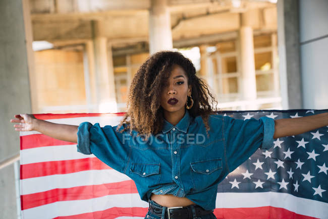 Jovem mulher em roupas de ganga segurando bandeira da América — Fotografia de Stock