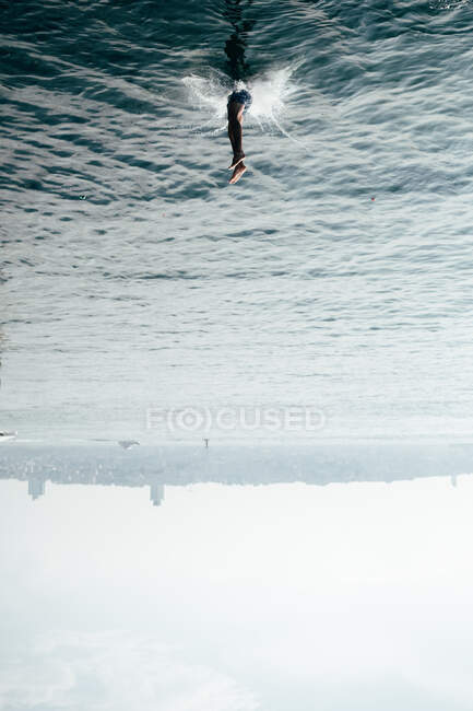Kopfüber aufgenommener unkenntlich gemachter Mann in Badehose stürzt in Istanbul ins Meerwasser — Stockfoto