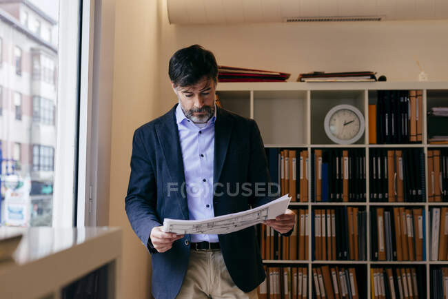 Взрослый человек с документами в офисе — стоковое фото
